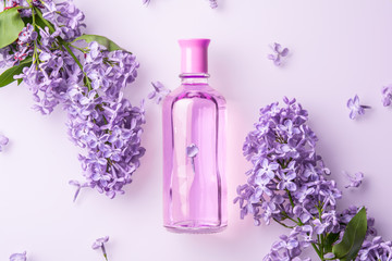 Obraz na płótnie Canvas pink perfume bottle with lilac flowers on white background