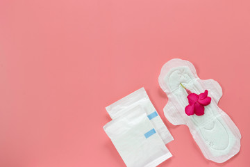 Pink flower on women's hygiene products or sanitary pad on pink background