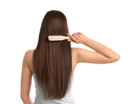 Back view of young woman with hair brush on white background