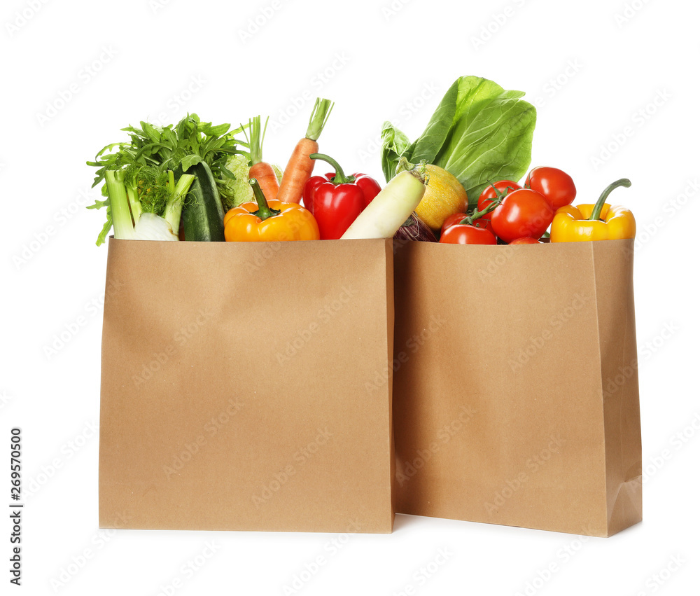 Poster Paper bags with fresh vegetables on white background