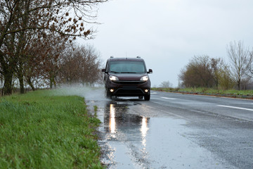 Wet suburban road with car on rainy day