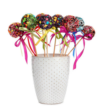Sweet cake-pops in glass on white background