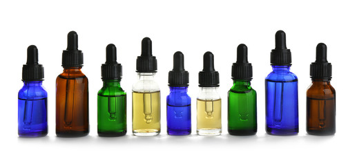 Different little bottles with essential oils on white background