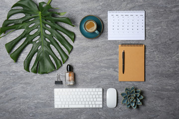 Flat lay composition with cup of coffee and office accessories on grey background