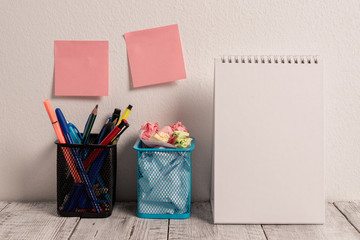 2 Sticky Notes on Wall 2 Mesh Pencil Pots Open Spiral Notebook on Work Desk