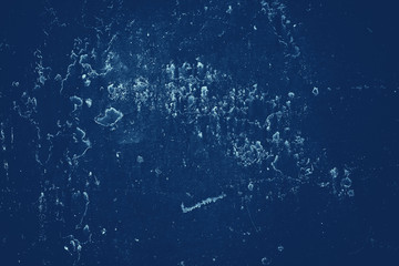 Vintage blue background. Rough painted wall of sapphire color. Imperfect plane of blue colored. Uneven old decorative toned backdrop of cyan tint. Texture of sapphirine hue. Ornamental stony surface.