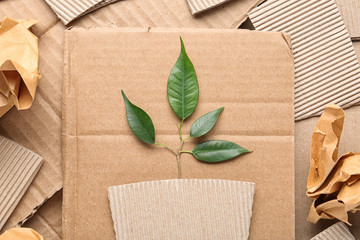 Flat lay composition with pieces of cardboard and green branch. Recycling problem