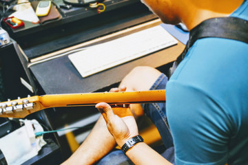 musician playing guitar in recording studio