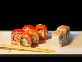 Sushi roll set on black background, close-up. Traditional Japanese oriental kitchen