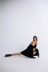 Obraz premium Fashion ballet. Young female ballet dancer in black bodysuit against white studio background. Asian ballerina like a fashion model. Style, contemporary choreography concept. Creative art photo.
