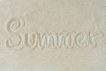 Fototapeta na wymiar The word summer is writting on the sand. Summer background.
