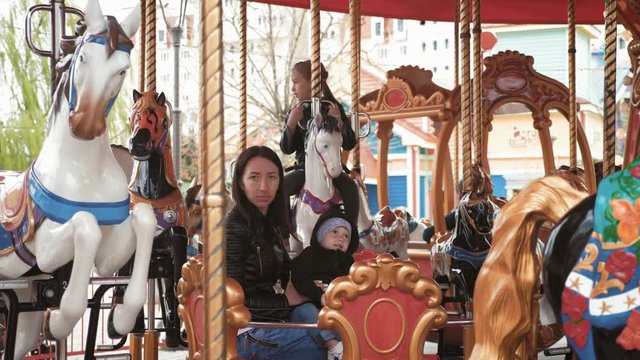 Carousel in a holiday park. Merry-go-round with horses.