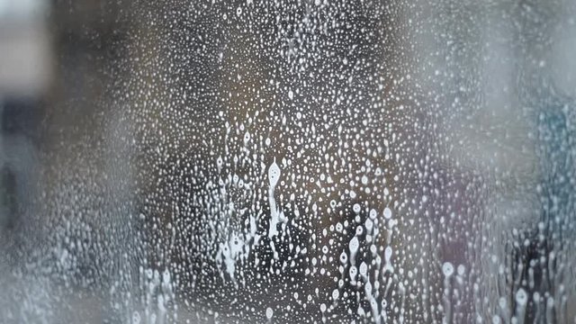 Spraying on windows with a window cleaning solution close up