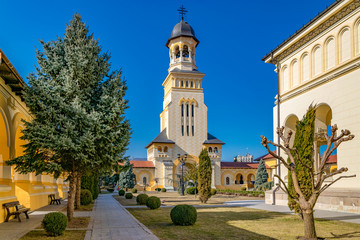 Fototapeta na wymiar Beautiful view to the Coronation Reunification Cathedral Bell Tower in Alba Iulia city, Romania. A Bell Tower on a sunny day in Alba Iulia, Romania