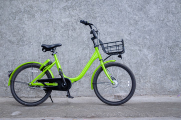 Green bicycle, black wheels parked on the wall.Vehicles with 2 wheels, driving with manpower.