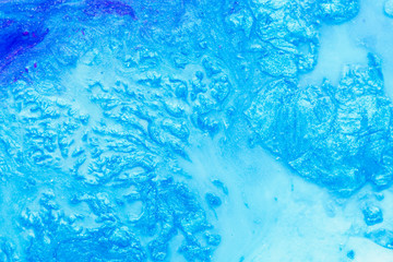 Abstract art texture background. Spilled dried polish design. Beautiful sky blue paint with bubbles and sparkling effect.
