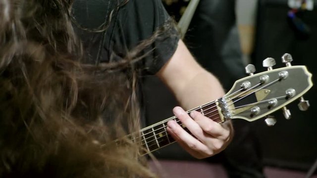 Lead guitarist in metal band. Guitar player performing on stage. Music video of punk, heavy metal or rock group. Slow motion. HD