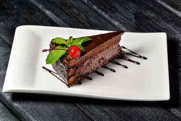 piece of chocolate cake on a plate with fork and knife
