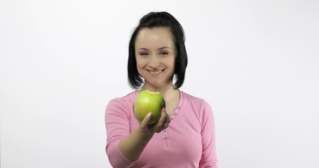 Young beautiful with green apple offer bite to viewer. Healthy nutrition