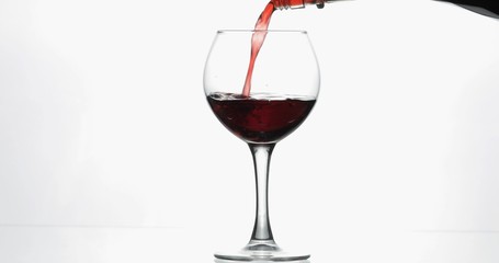 Rose wine. Red wine pour in wine glass over white background