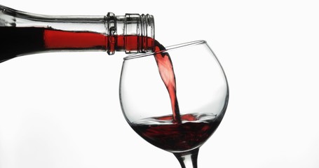 Rose wine. Red wine pour in wine glass over white background