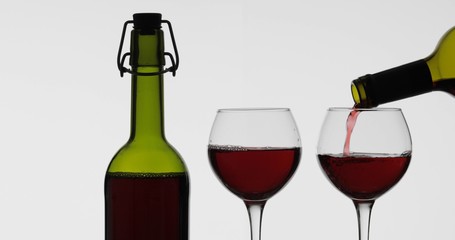 Rose wine. Red wine pour in wine glass over white background
