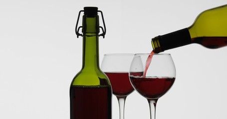 Rose wine. Red wine pour in wine glass over white background