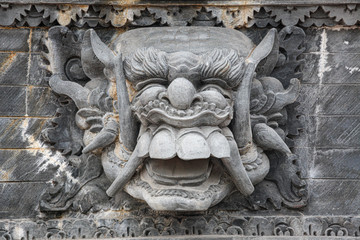 Stone face sculpture in wall at Bali Indonesia