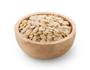 Pumpkin seeds in wood bowl on white background