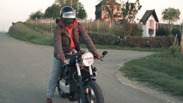 Motorcyclist starting his custom bike and driving away