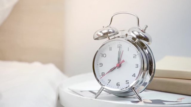 cropped view of young woman throwing retro alarm clock 