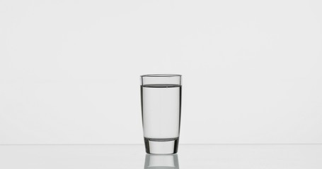 Shot of vodka in glass. White background