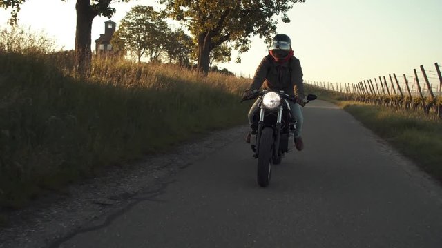 Motorycyclist cuising on country road