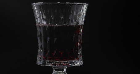 Rose wine. Red wine in wine glass over black background. Silhouette