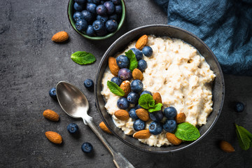 Oatmeal porridge with fresh berries and nuts top view. 