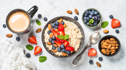 Oatmeal porridge with fresh berries and nuts top view. 