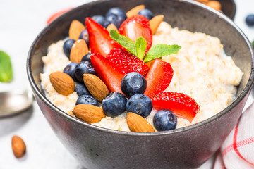 Oatmeal porridge with fresh berries and nuts. 