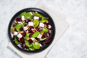 Fresh salad from spinach, beet and feta cheese with walnut.
