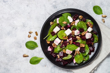 Fresh salad from spinach, beet and feta cheese with walnut.