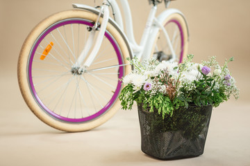 Fototapeta na wymiar pink vintage bicycle with flower basket isolated on beige background