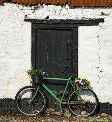 Fototapeta na wymiar bicycle parked against an old Irish cottage