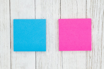 Two blank sticky notes on weathered whitewash textured wood background