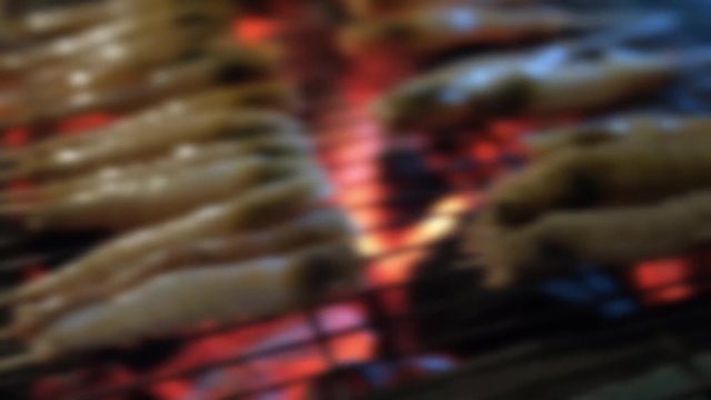 Blurry footage of fresh shrimp, prawn grilled bbq seafood on charcoal stove for night party. Royalty high-quality free stock footage of grilling fresh prawns or shrimps on the flaming barbecue grill