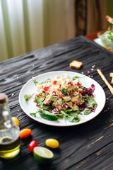 Fresh salad with chicken, cheese, leaves, beets, spinach on a dark wooden background