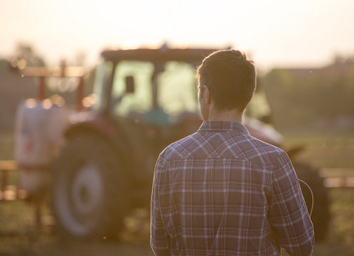 Farmer in front of tractor in field