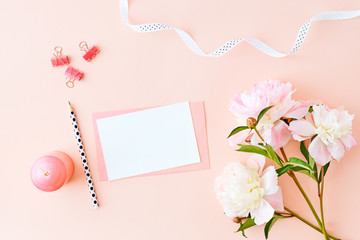 Mockup wedding invitation and envelope with light pink peonies on a pink background