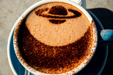 Close up blue a cup of hot chocolate with cocoa powder Saturn shape decoration 