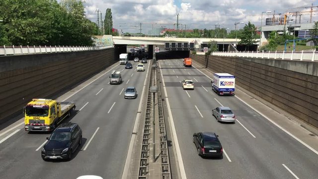 Busy Berlin Motorway / Highway (Autobahn) with many cars and trucks driving by during rush hour on a sunny day - high angle shot