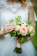 Bridal bouquet in the hands of the newlyweds