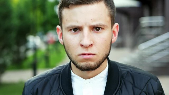 Man has a angry look on his face. Close-up portrait of man frowning with an displeased face